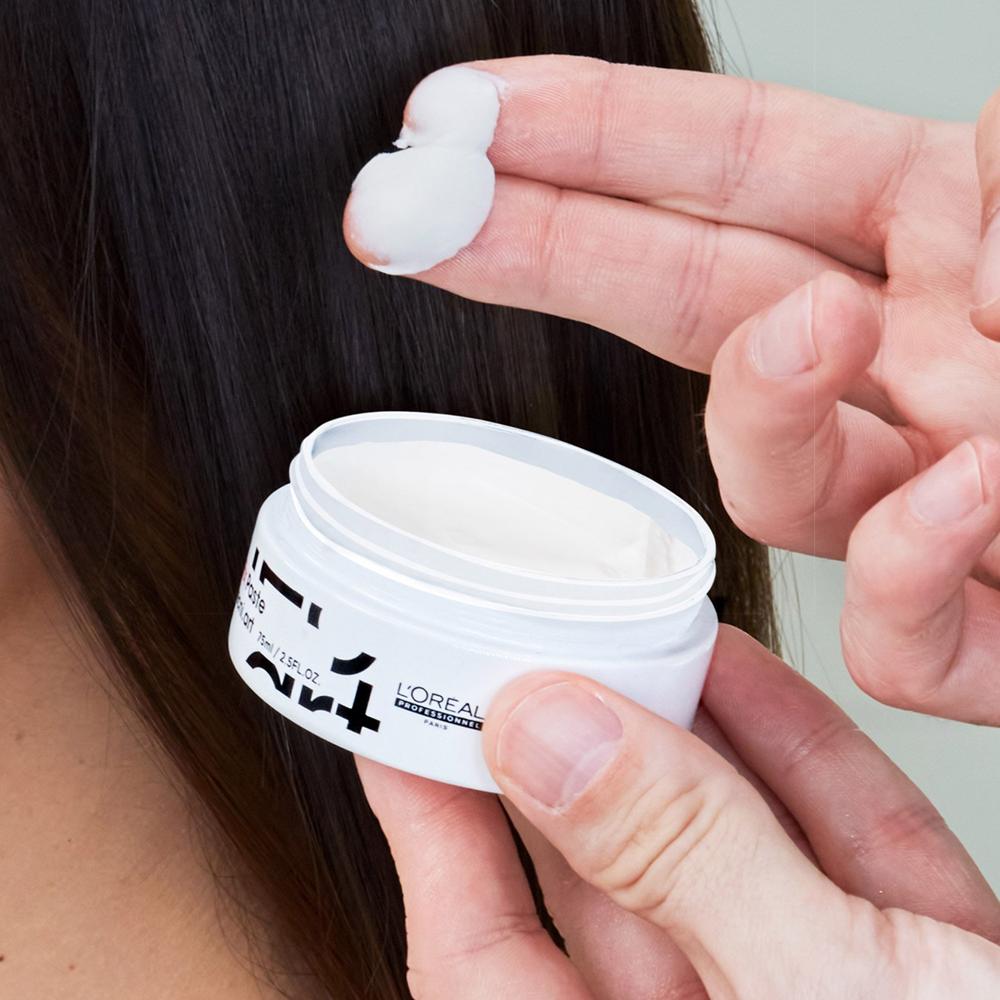 Malé množství L'Oréal matné pasty na vlasy na prstech před aplikací